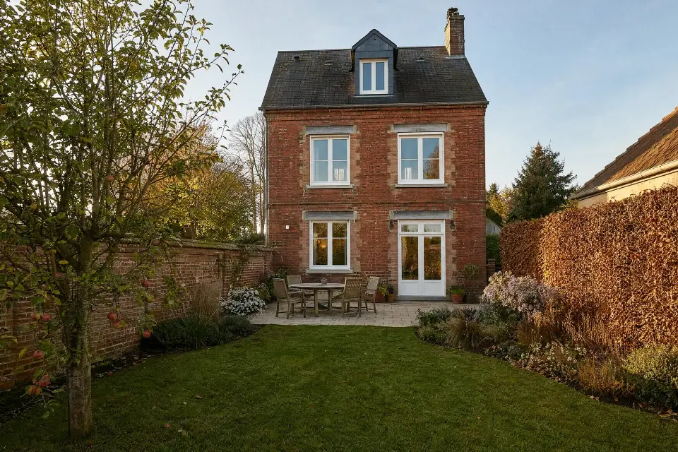 Façade d’une maison de banlieue avec jardin, lumière de fin d’après-midi
