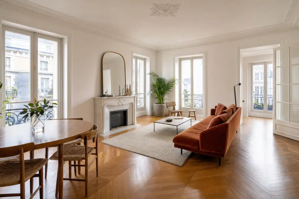 Salon traversant avec parquet et grandes fenêtres